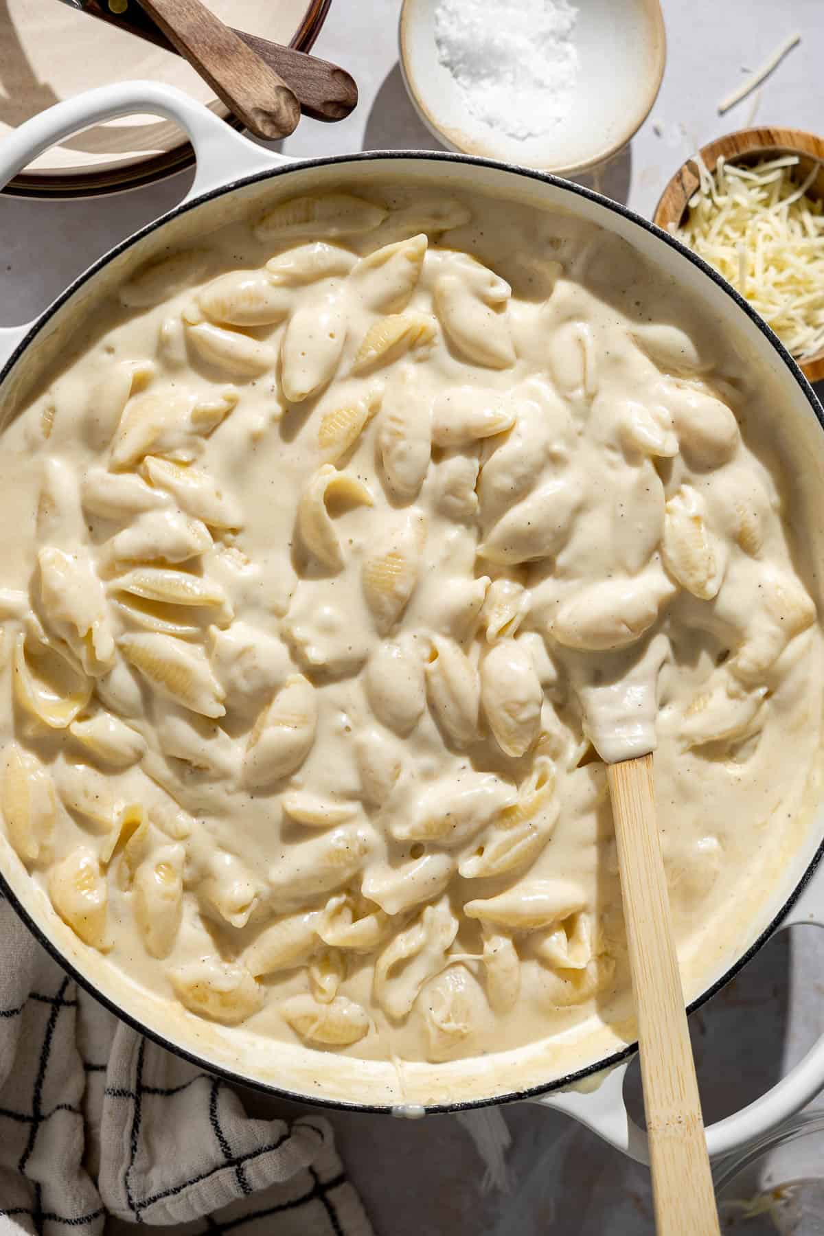 creamy white cheddar mac and cheese in a skillet with a spatula.