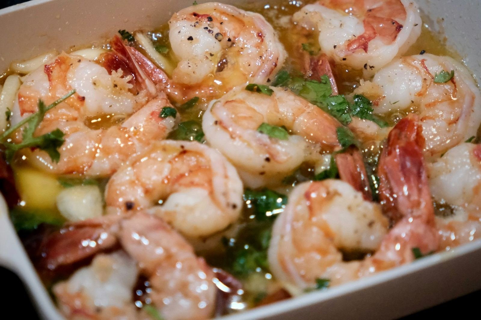 Garlic butter shrimp with herbs in a white baking dish